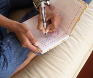 Image of someone writing in a journal